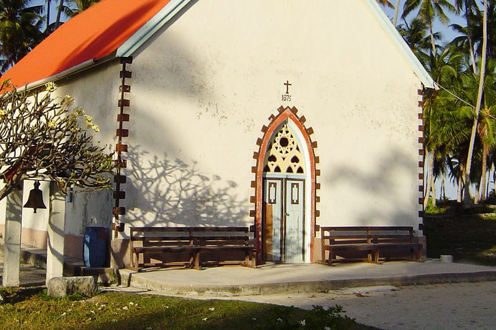 Porche de l'église de Raroia avec la pierre du marae