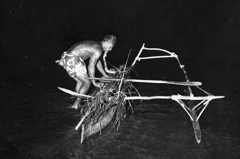 Pêcheur en pirogue de nuit. Defap